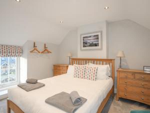 um quarto com uma cama com duas toalhas em Congl Cae em Pwllheli