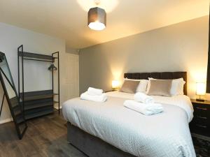 um quarto com uma cama grande com duas toalhas em Rothwell Close Serviced Two Bed Apartment em Telford