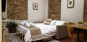 a bedroom with a bed with a table and chairs at Ayuntamiento - Precioso con parking y WIFI in Oviedo
