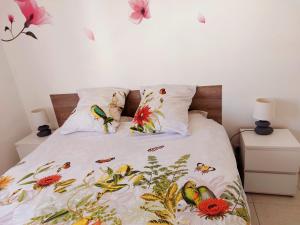 アンティーブにあるLes jardins d'Antibesのベッドルーム1室(ベッド1台、鳥と花付)