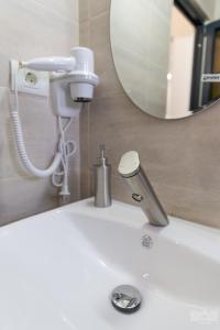 a bathroom sink with a blow dryer and a mirror at Casa Familia Vladoi in Murfatlar