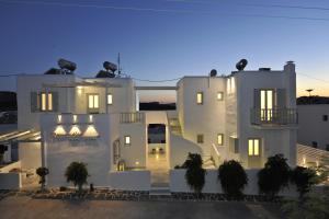 un grande edificio bianco di notte con luci accese di Romantica Suites a Naoussa