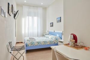 um pequeno quarto com uma cama e uma mesa em Affittacamere La Fortuna em Lucca
