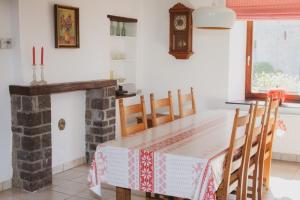 a dining room with a table and a fireplace at La petite maison du moulin de Scoville. in Hamois