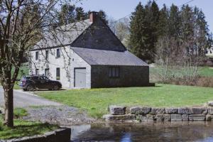 una casa con un coche aparcado delante en La petite maison du moulin de Scoville., en Hamois