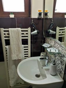 un bagno con un lavandino bianco e uno specchio di Sophia Central Studio a Iaşi