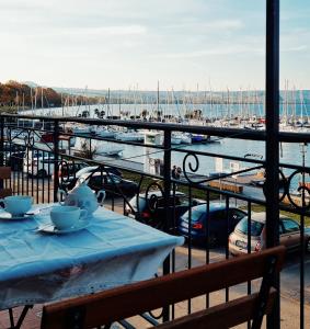 a table with two tea cups on a balcony with a marina at La casetta del nonno in Capodimonte