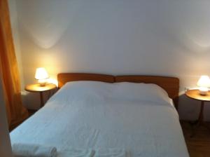 ein Schlafzimmer mit einem Bett und zwei Lampen an beiden Seiten in der Unterkunft Apartment Žarko in Brna