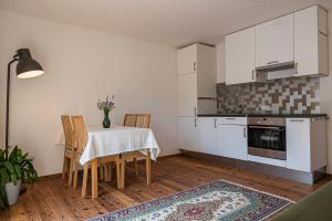 - une cuisine et une salle à manger avec une table et des chaises dans l'établissement Haus18. 4, à Sluderno