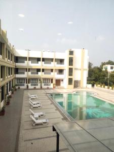 a hotel with a swimming pool and lounge chairs at Inspira Resort & Spa in Silvassa