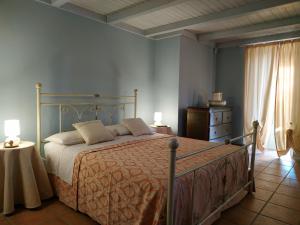 a bedroom with a bed and two lamps and a dresser at Casina Rossa di Pietrafitta in Casarano