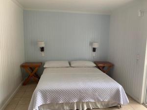 a bedroom with a large bed and two tables at Caribbean Villas Hotel in San Pedro