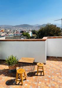 a table and two stools on top of a roof at Hostal Makea Pachuca in Pachuca de Soto