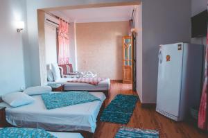 a small room with two beds and a refrigerator at Gina Motel Dahab in Dahab