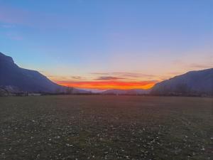 a sunset over a field with mountains in the background at Konak -Guest house -Ramonda Serbika in Niš