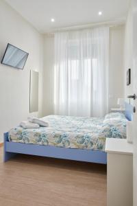 Affittacamere La Fortuna في لوكّا: غرفة نوم بيضاء بها سرير ونافذة