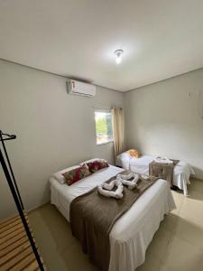 a hotel room with two beds and a air conditioner at Village Brasil, Lençóis in Lençóis