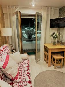 een woonkamer met een bank en een tafel bij les Cimes d'Or Mont blanc in Les Contamines-Montjoie