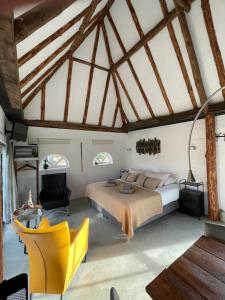 a bedroom with a large bed and a yellow chair at Hof van Eersel in Eersel