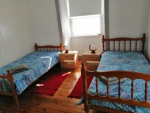 a bedroom with two beds and a window at Casa do Rossio in Fajazinha