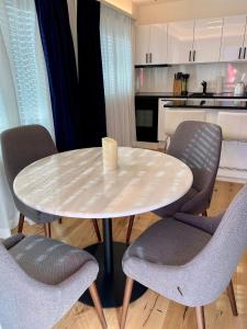 - une table et des chaises blanches dans la cuisine dans l'établissement Wunderstay Alpine 303 New Studio with Lake & Mountain View, à Engelberg