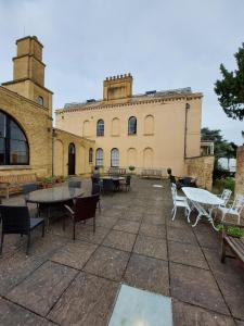 a building with tables and chairs in front of it at Moggerhanger Park, Moggerhanger in Sandy