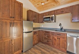 uma cozinha com armários de madeira e um frigorífico de aço inoxidável em The Lodge by Sunapee Stays em Sunapee