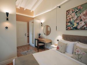 1 dormitorio con cama y escritorio en CASTRELLO Old Town Hospitality, en Ioannina