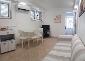 a kitchen and dining room with a table and chairs at Villa Radoš - 4 Sterne, 3 Apartments für maximal 18 Gäste in Supetar