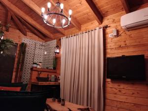 a room with a curtain and a television and a chandelier at Cosy room in Majdal Shams