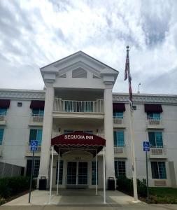 漢福德的住宿－紅杉汽車旅館，前面有旗帜的大型白色建筑