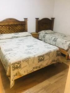 two beds sitting next to each other in a room at Hostal Makea Pachuca in Pachuca de Soto