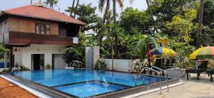 - une piscine en face d'une maison dans l'établissement Cherai Beach Residency, à Cherai Beach