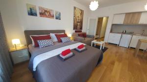 a bedroom with a large bed and a kitchen at Apartments Delta A Blok - Savada in Belgrade