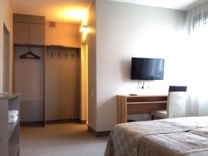 ein Hotelzimmer mit einem Bett, einem Schreibtisch und einem TV in der Unterkunft AmberSeason Hotel in Selenogradsk