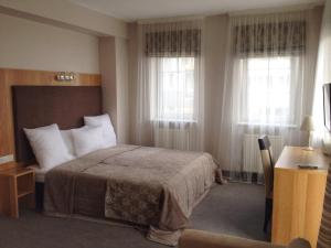Un pat sau paturi într-o cameră la AmberSeason Hotel