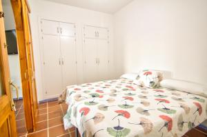 a bedroom with a bed with a colorful comforter at Con el Alma in Benaocaz
