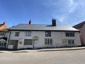 an old white building on the side of a street at One Abbey Lane in Southam +2 photos