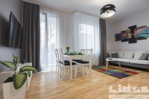 a kitchen and living room with a table and chairs at Millennium Awangarda Grey in Warsaw