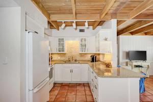 a kitchen with white cabinets and a white refrigerator at House of the Sun in Siesta Key