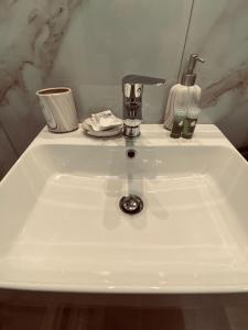 a white sink with a faucet on top of it at SMALL MEISONETTE NEAR THE METRO vipgreece in Athens
