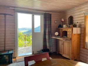 eine Küche mit einem großen Fenster mit Blick auf einen Balkon in der Unterkunft Ateljéstugan med magisk utsikt in Nordingrå