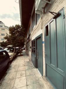 chodnik obok budynku z niebieskimi drzwiami w obiekcie Small Meisonette Near The Metro VIPGreece w Atenach