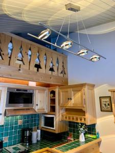una cocina con armarios de madera y un mostrador de azulejos verdes en LES COMBETTES, en Les Contamines-Montjoie