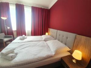 a bedroom with a large white bed with red walls at Lux Resort in Kraśnik