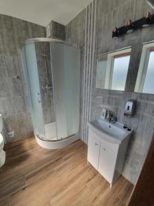 a bathroom with a sink and a shower and a mirror at Lux Resort in Kraśnik