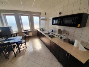 a large kitchen with a table and a microwave at Lux Resort in Kraśnik