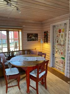 ein Esszimmer mit einem Holztisch und Stühlen in der Unterkunft Ateljéstugan med magisk utsikt in Nordingrå