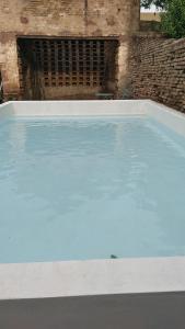 a large pool of blue water in front of a building at LA FLORIDA - CASA PUEBLO in San Antonio de Areco