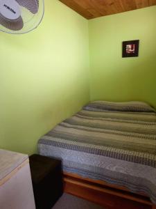 a small bedroom with a bed in a green wall at La Casa Maruja in Lima